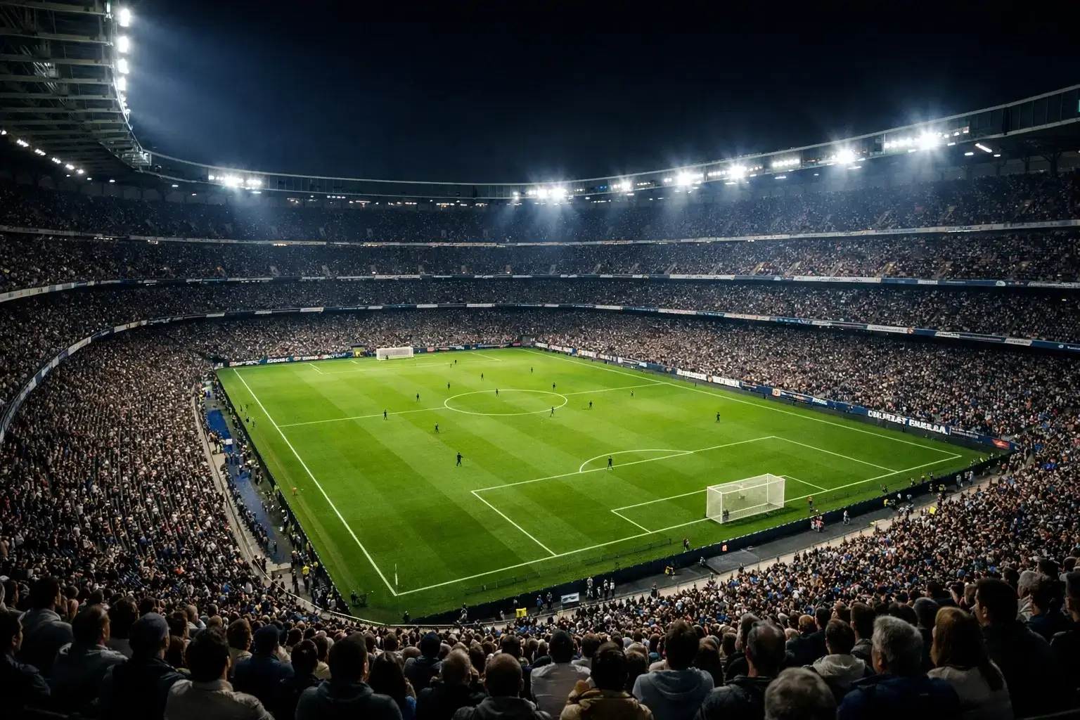 Estadio de fútbol iluminado durante un partido nocturno con aficionados en las gradas