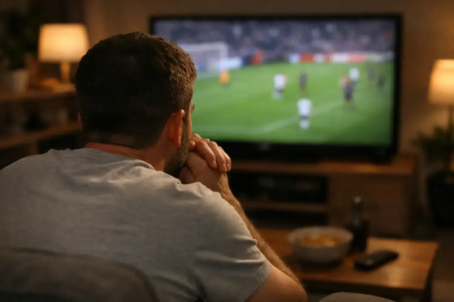 Aficionado de f&uacute;tbol con expresi&oacute;n tensa viendo partido importante