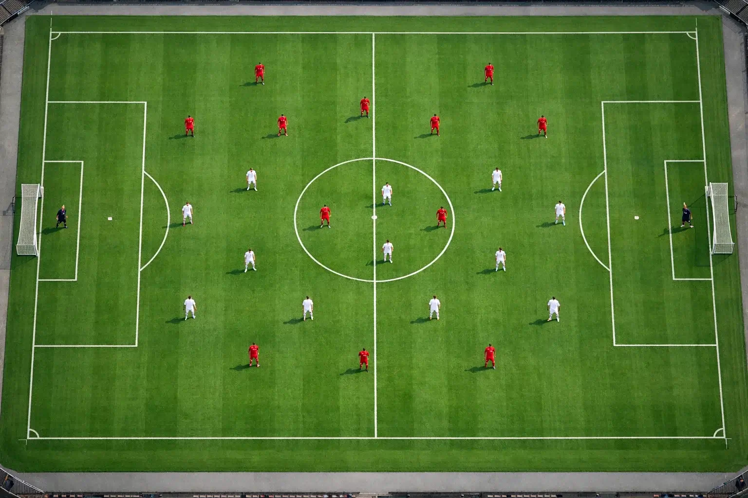 Vista a&eacute;rea de campo de f&uacute;tbol con jugadores en formaci&oacute;n t&aacute;ctica